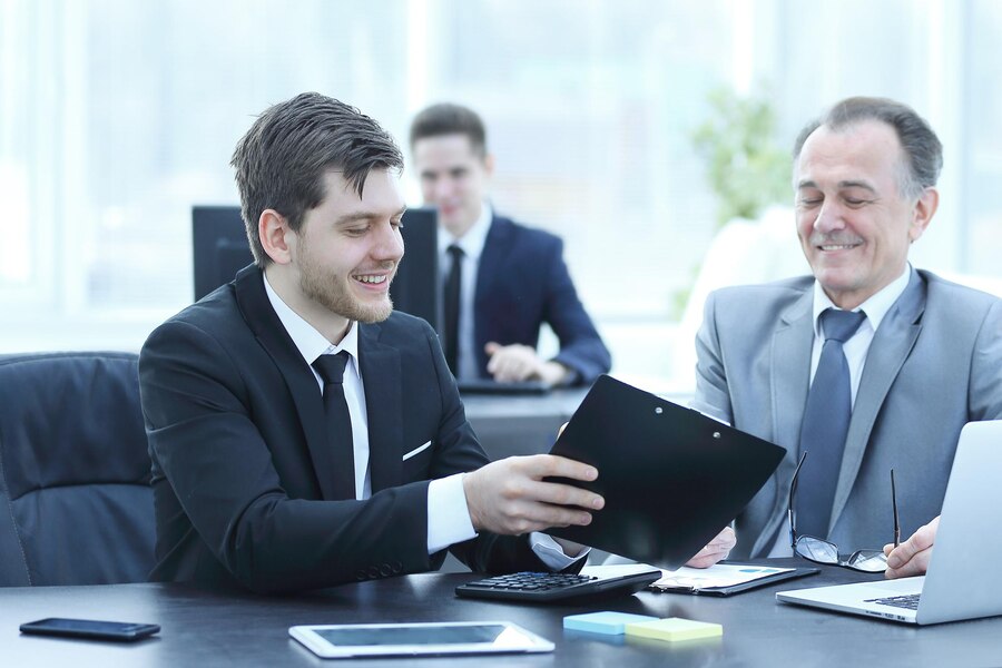 adult-businessman-discussing-financial-documents-with-young-colleague_160672-31957