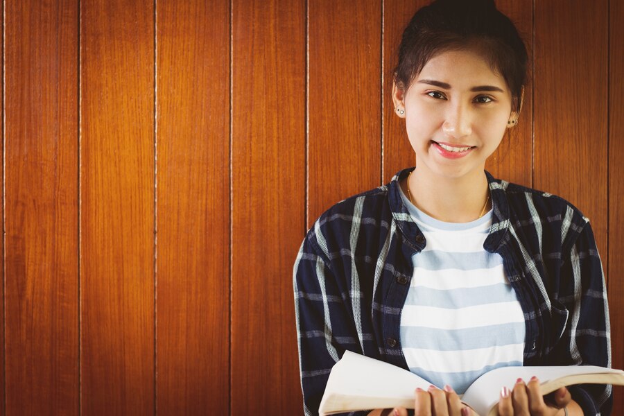 student-teen-girl-reading-book-with-happy_35934-253